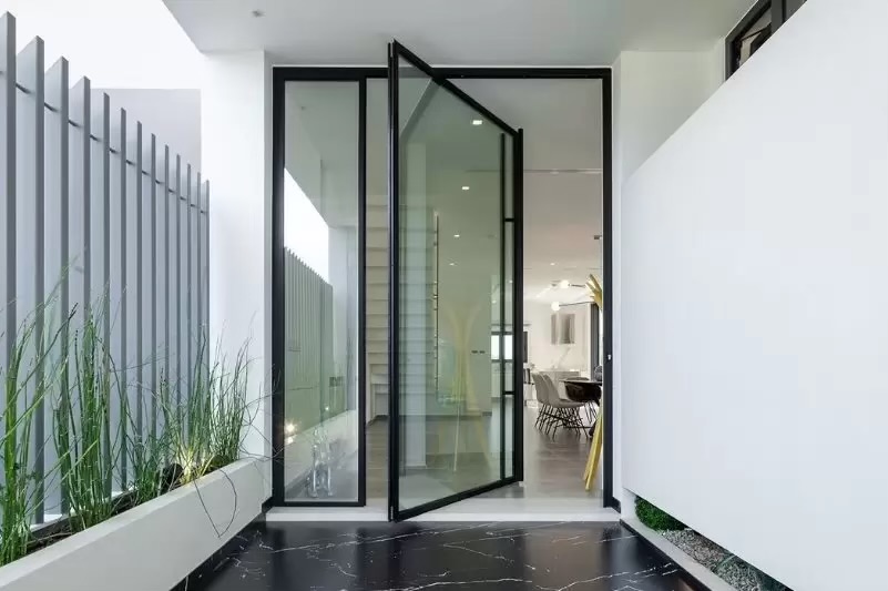 New home construction in Southwest Florida — custom modern entry with floor-to-ceiling pivot glass door