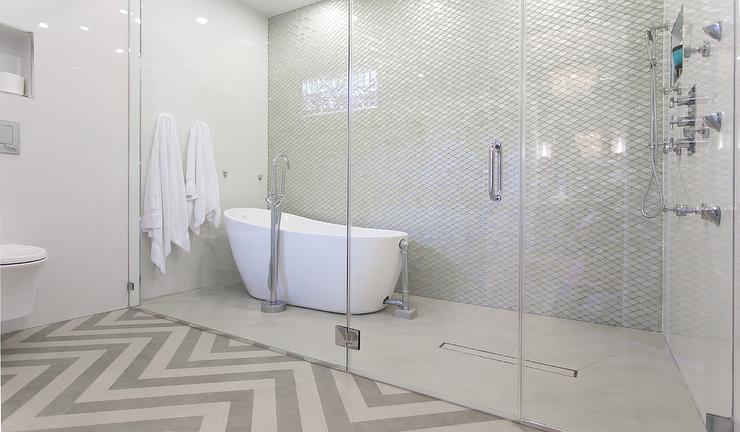 Spa-style bathroom with freestanding soaking tub, frameless glass shower and chevron tile floor
