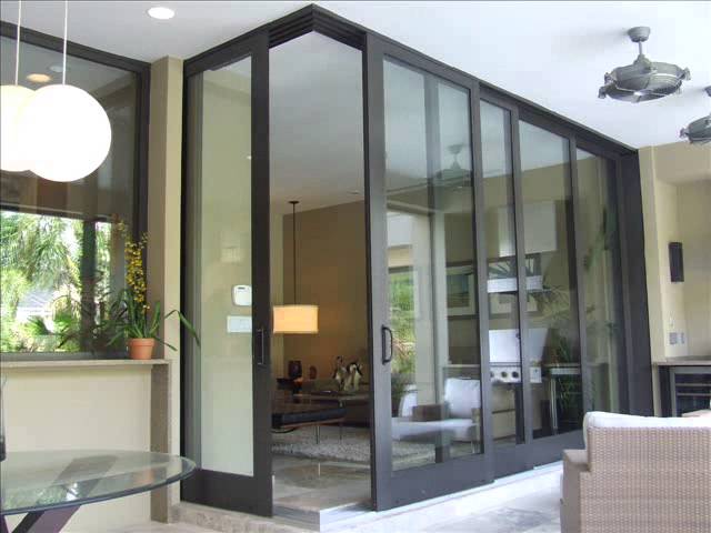 Indoor-outdoor living with sliding glass patio doors, covered lanai and seamless living-room transition