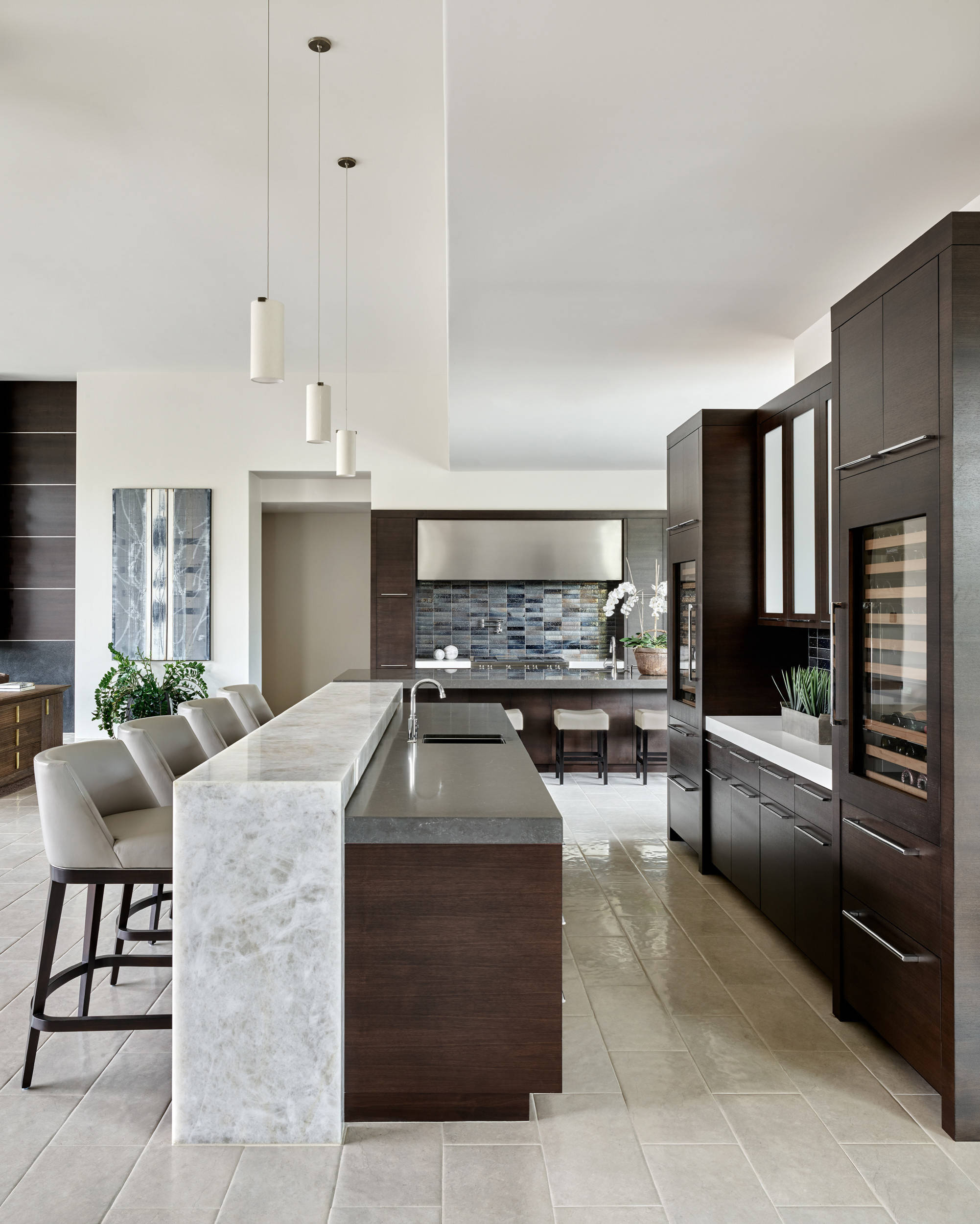 Complete full home remodel with contemporary dark cabinetry, marble waterfall island and tile backsplash in Fort Myers Florida