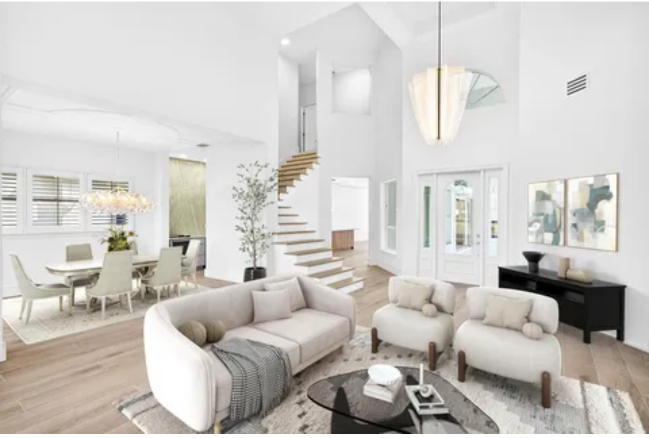 Open-plan two-story living room renovation with floating staircase and statement chandelier